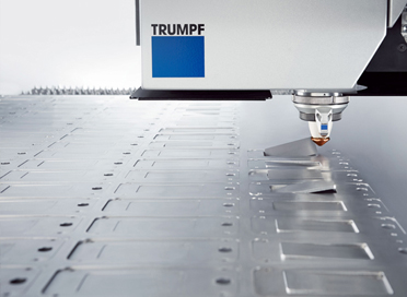 Photo close up of a trumpf laser head, cutting into a sheet of metal